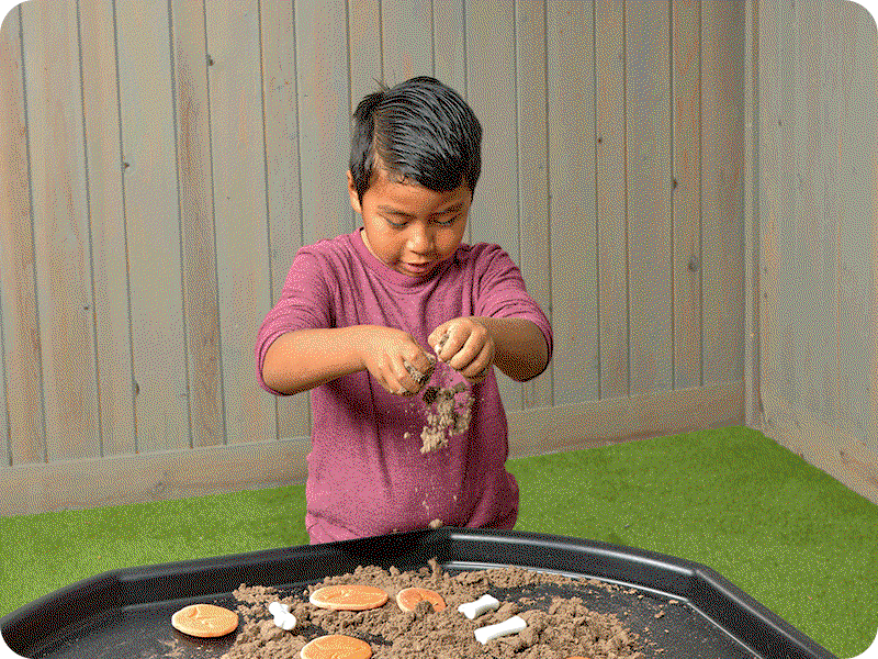 A boy playing outside with Excellerations® Wonder Dirt™