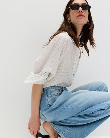 Women wearing a White Mix Lyocell Rich Checked Collared Oversized Shirt and Light Indigo Cotton Rich Mid Rise Wrap Front Wide Leg Jeans