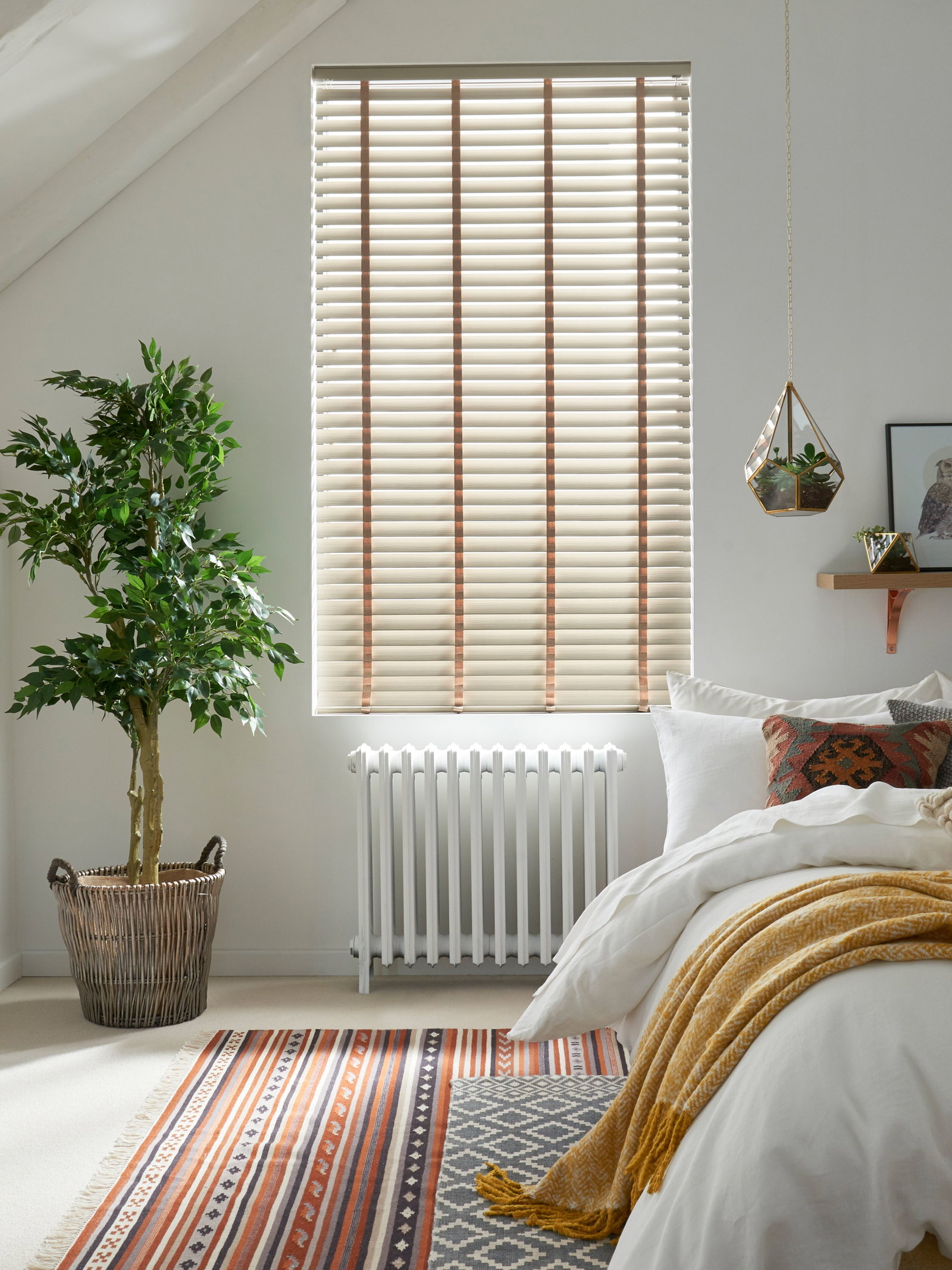 Wooden window blinds in a Scandi style bedroom 