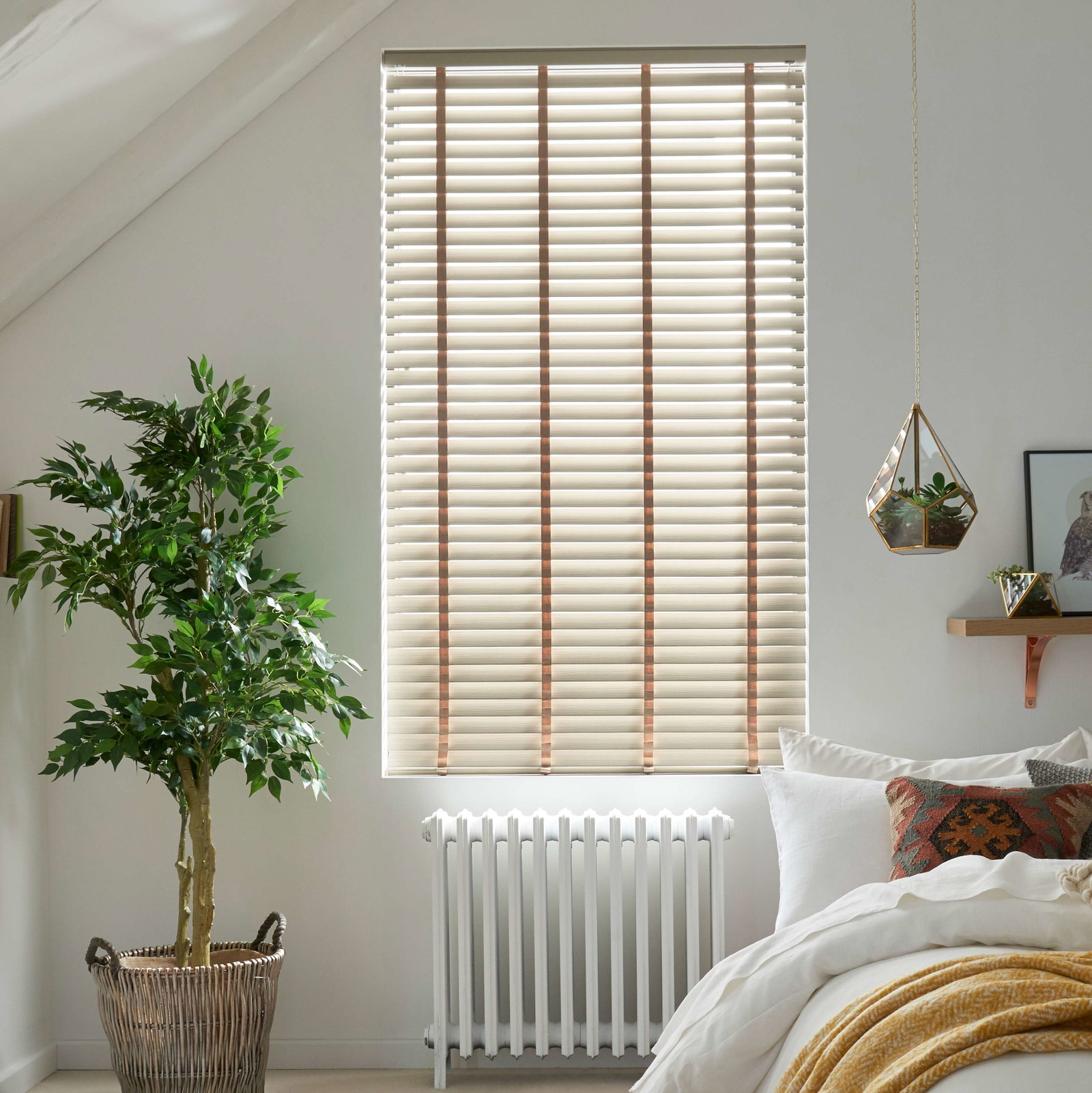 Wooden window blinds in a Scandi style bedroom 
