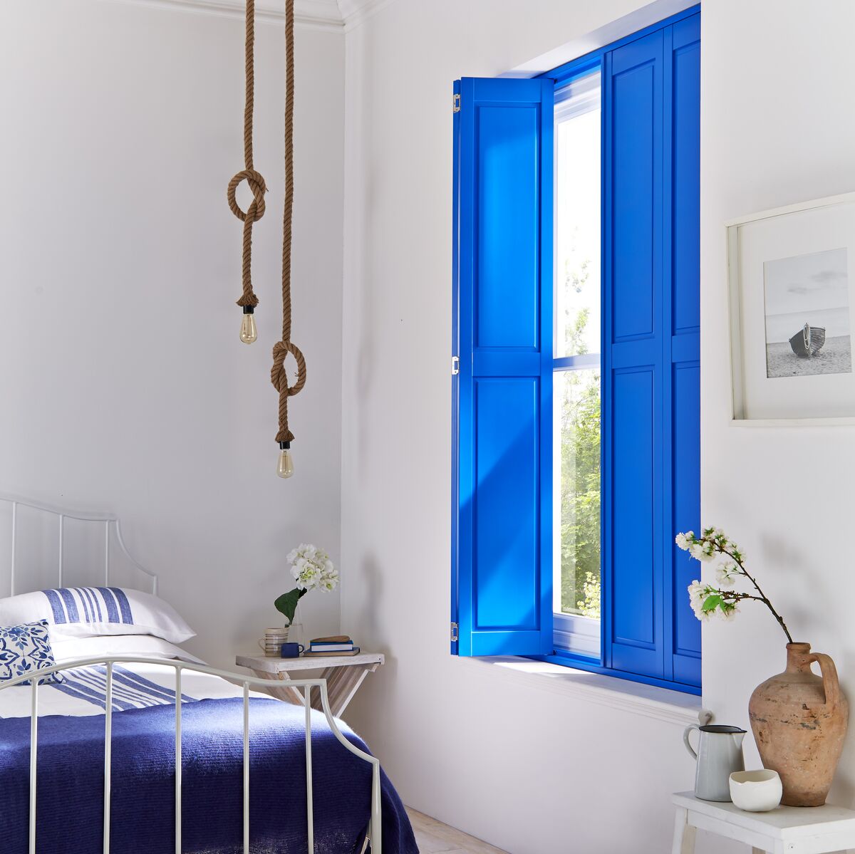 Blue coloured shutters for a Greek inspired island bedroom