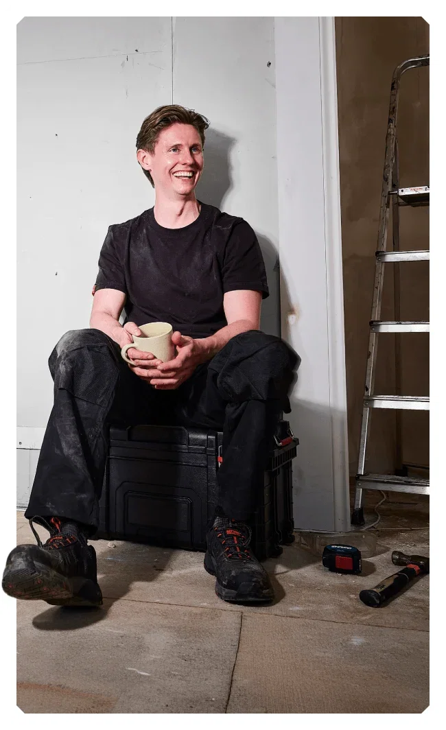 Image of 2025 winner, Martin Daly, sat with a cup of tea and taking a break from his DIY job