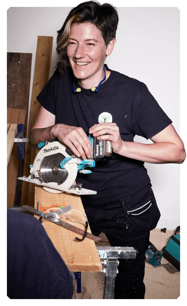 Image of 2023 winner, Astrid Arnold, smiling and leaning against a Makita mitre saw.