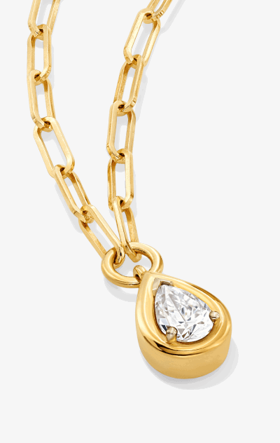 Gold necklace with teardrop diamond pendant encased in gold. 