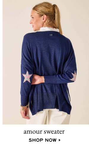 Amour Sweater - shop now - image of a woman wearing a long sleeve navy sweater with red and white star elbow patches