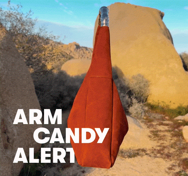 GIF of a spinning orange bag among desert rocks, with “ARM CANDY ALERT” text overlay. 