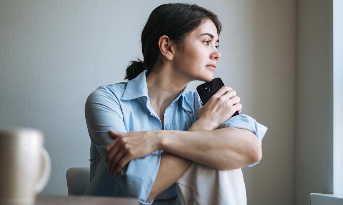 Woman thinking with phone