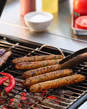 Veggie dogs being cooked on a charcoal grill.