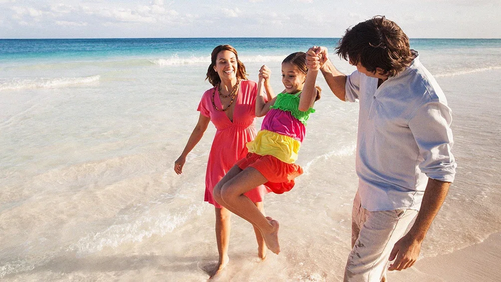 Image description: Family of 3 walking on the beach, in Puerto Rico.
