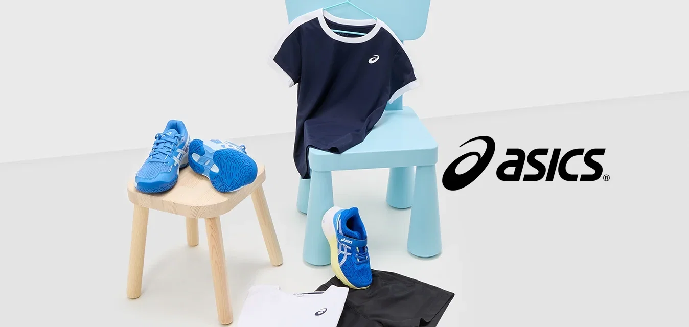 Blauwe sport schoenen met witte accenten, marineblauwe t-shirt met witte bies, zwarte shorts, en een wit shirt op lichte oppervlakken met een blauwe stoel.