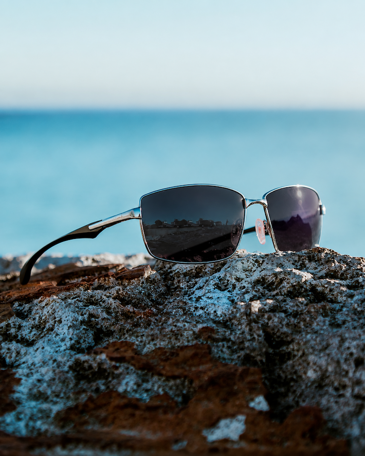 EnChroma Colorado frames with mirrored lenses on coastal rock