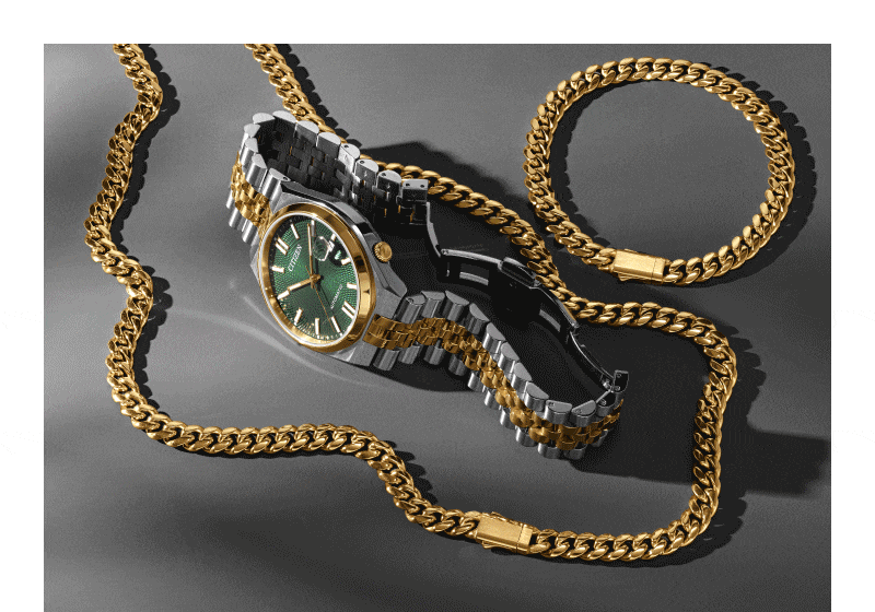 Slideshow showing set of gold chain, matching bracelet and two-tone metal watch with green face. Stack of gold rings, each one has a different colored gemstone in the center. 