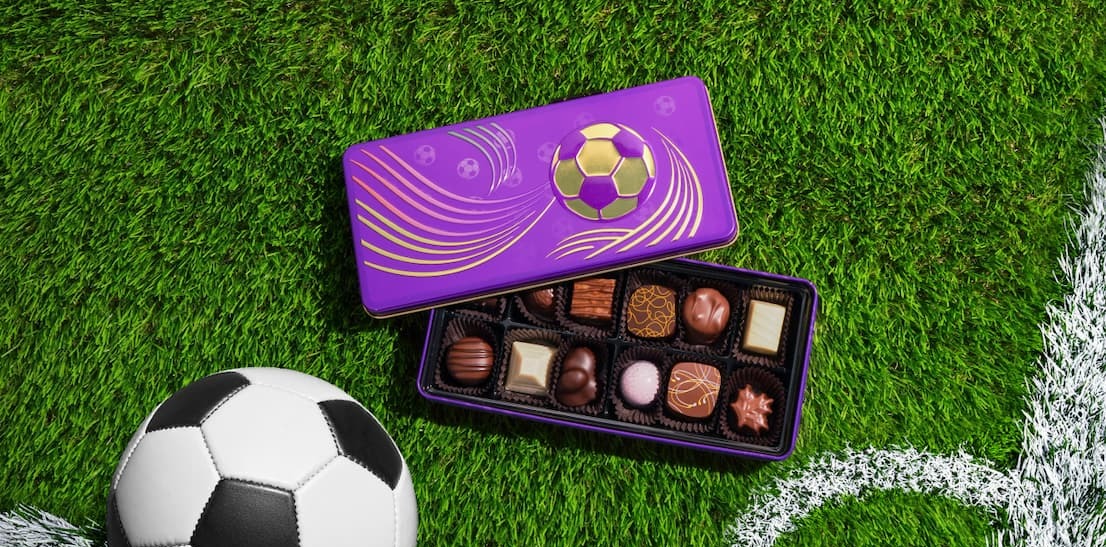 The Golden Soccer Gift Tin next to a soccer ball