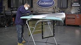 Sanding a car fender on a work stand