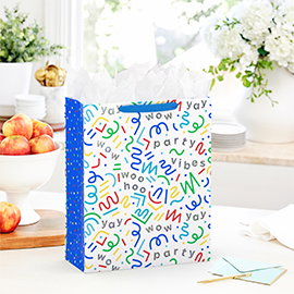 Table with gift bag, fruit and flowers.