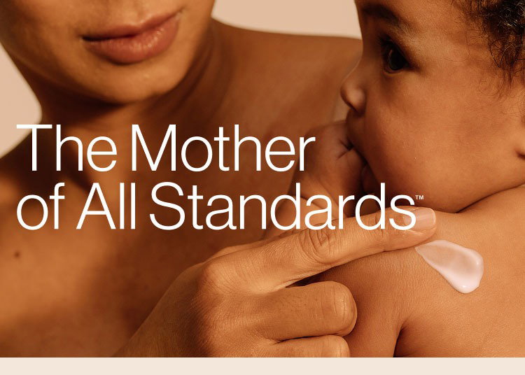 Mom holding baby and applying Honest Sensitive Rich Cream on its shoulders