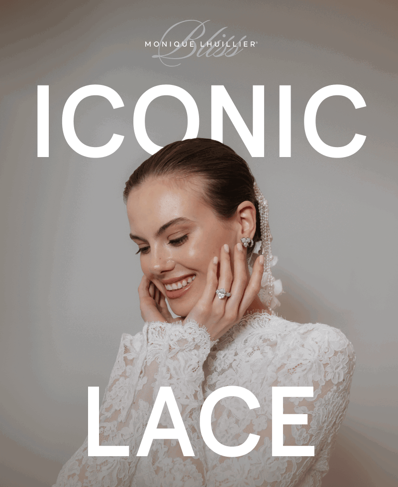 A model wearing diamond earrings and a ring in a white lace wedding dress.