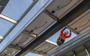 a construction worker on a roof with some panels
