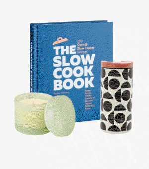 A blue cookbook next to a green glass candle and patterned water bottle. 