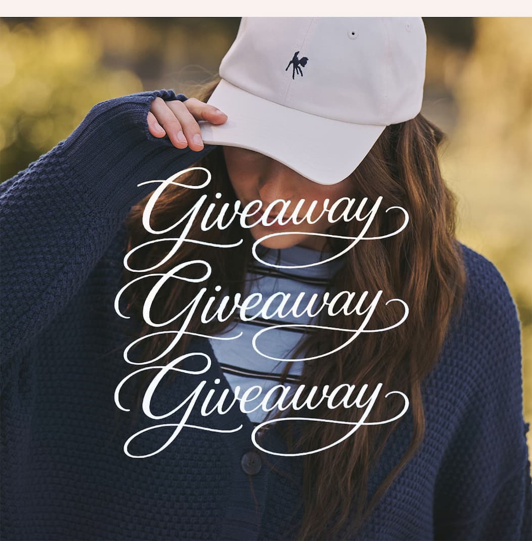 Model in white Julia Ball Cap, striped tee, and navy cardigan. Text: “Giveaway Giveaway Giveaway.”