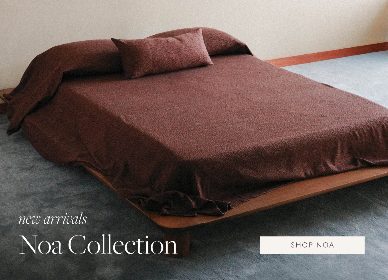 Maroon bed cover and pillow in a minimalist bedroom setting