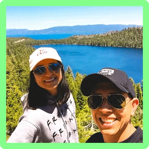 Image description: Two travelers posing with Lake Tahoe’s Emerald Bay in the background