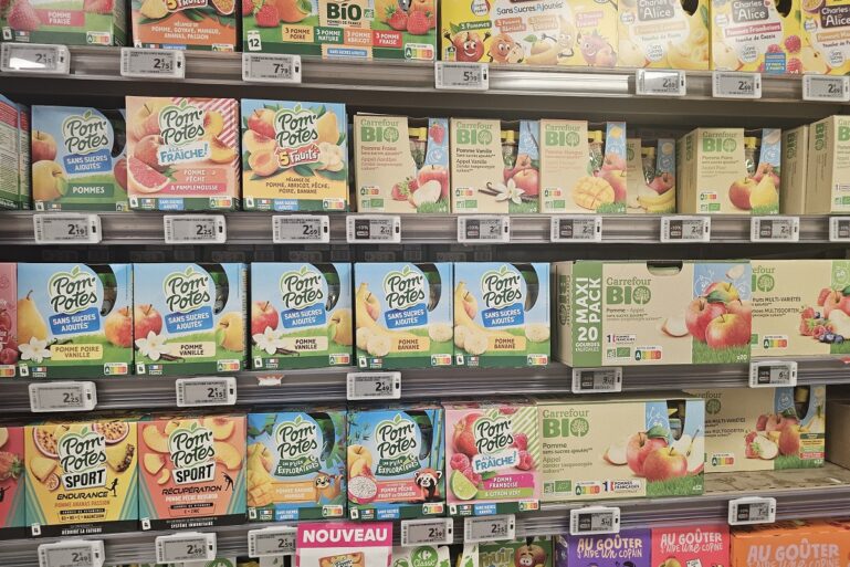Un rayon de compotes en gourde pour enfants dans un supermarché.