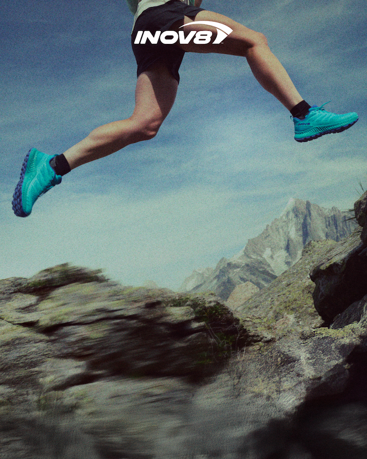 Athlete running fast across alpine rocks