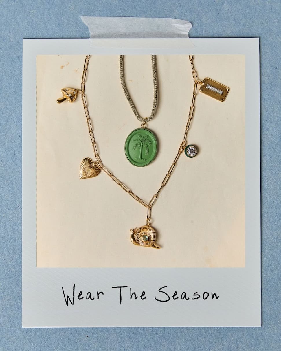 Flat lay image of a custom charm necklace and Palm Cameo on a Gold Lurex Cord