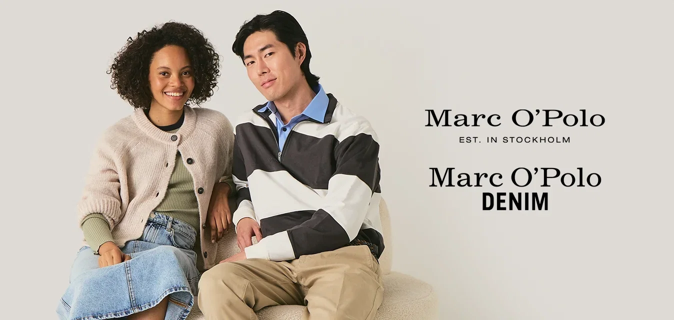 Cardigan beige lavorato a maglia sopra una maglia verde, gonna di jeans e stivali marroni; uomo in giacca bianca e nera, pantaloni beige e scarpe marroni su una sedia rotonda tessurizzata.