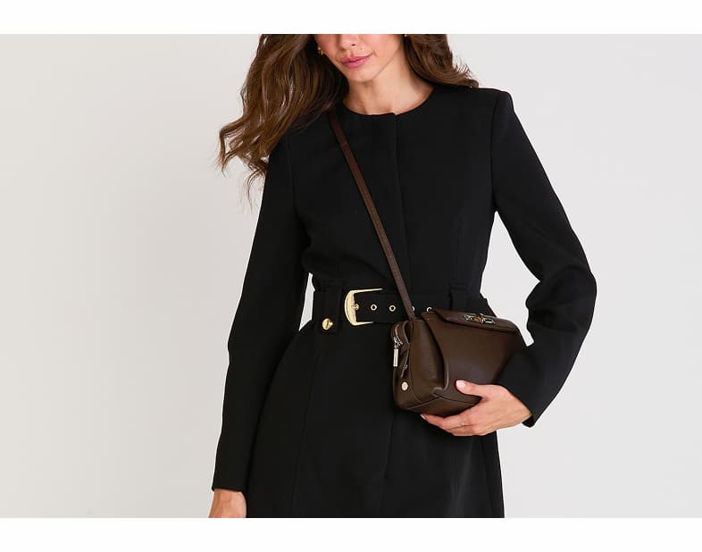 Model wearing the Hammitt Charlotte Med crossbody bag in Mahogany Pebble leather.