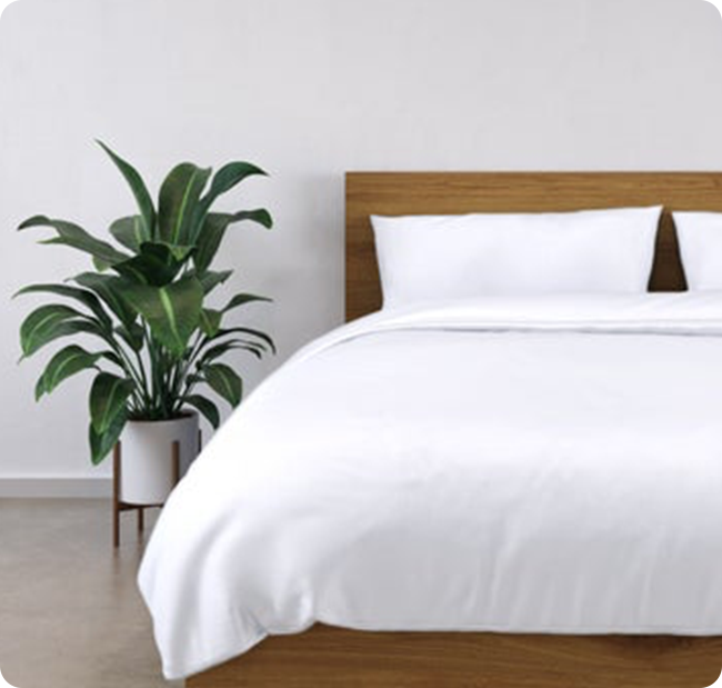 A bed with soft white 100% Bamboo sheets and duvet cover on it