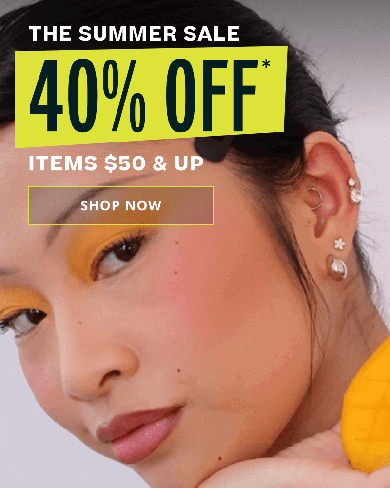 Model, displaying dainty hoops & huggies. Summer Sale.  40% OFF* Select Items $50 & Up. Click here to shop now