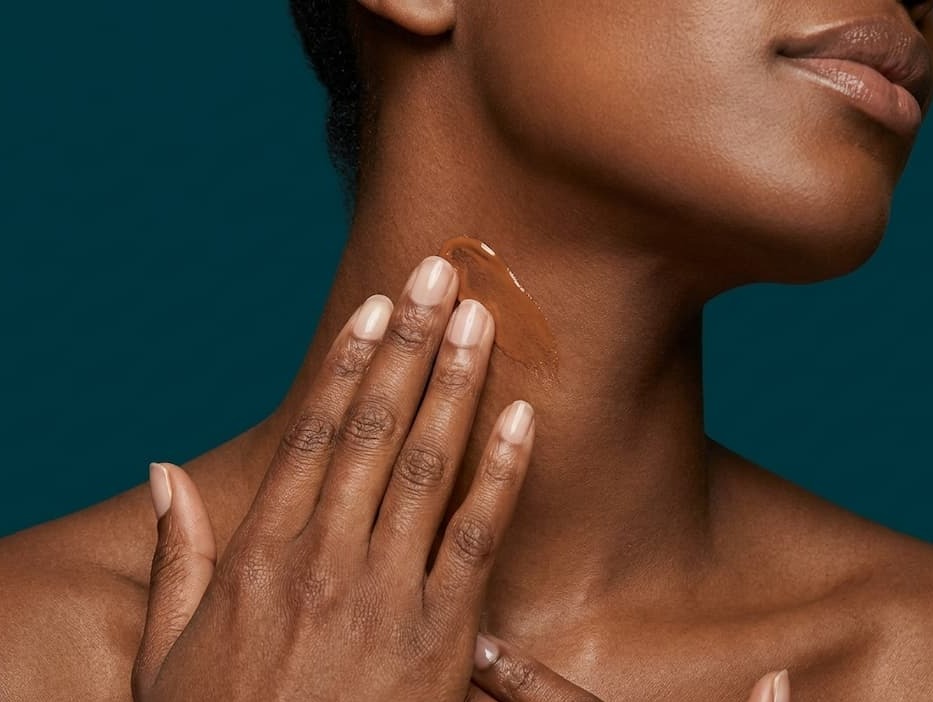 Woman putting sunscreen on her neck
