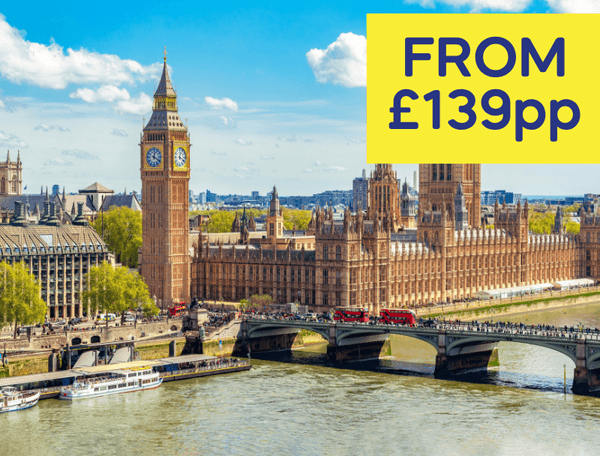 A view of the Houses of Parliament and Big Ben beside the River Thames on a sunny day.