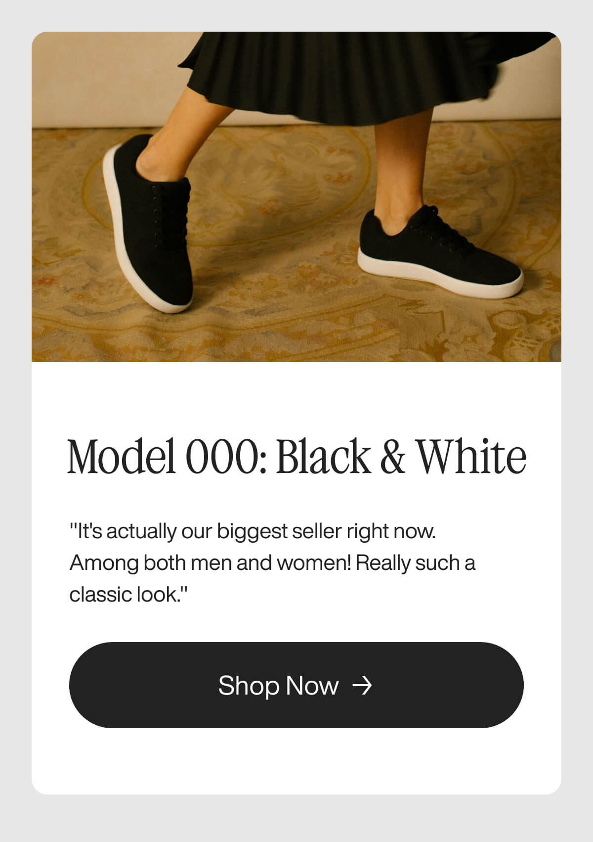"Model 000 sneakers in black and white worn with a skirt. A popular unisex choice. Shop now button included."