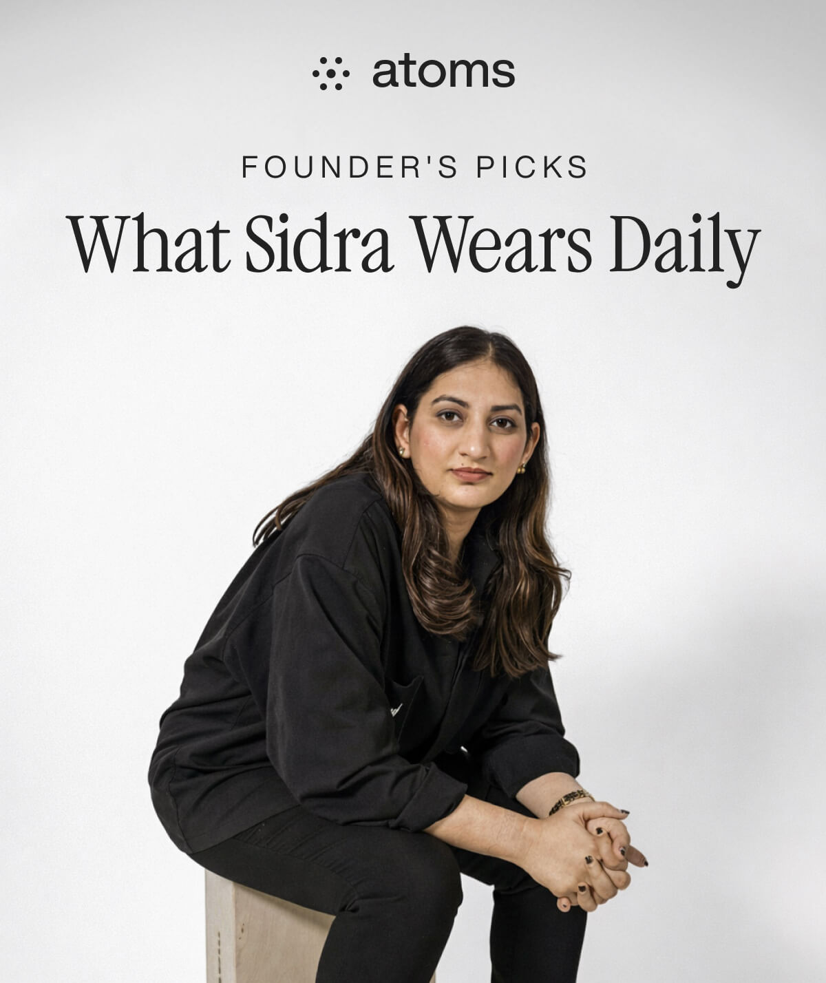 "Woman in black outfit sits on stool under "Founder's Picks: What Sidra Wears Daily" text, promoting Atoms fashion."