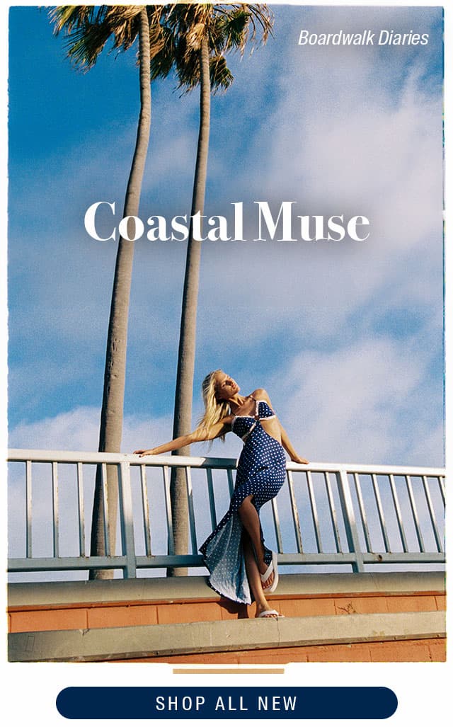 Coastal Muse. Model wearing a navy maxi dress with polka dots. Shop new. 