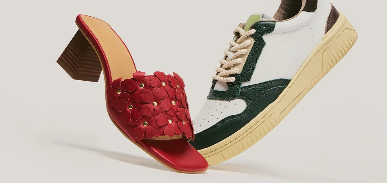 Sandalo rosso con tacco e motivo floreale abbinato a una sneaker casual bianca e verde con suola beige su sfondo neutro.