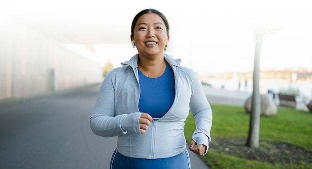 Woman in blue running on a paved road