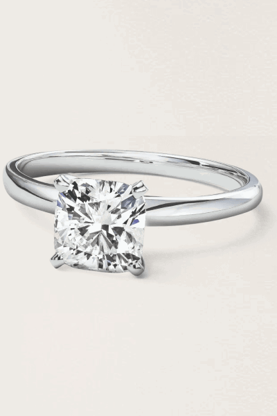 A solitaire ring with a silver band and a square cut diamond in the center.