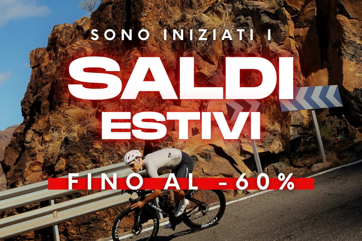 Cyclist descending a mountain road by rocky cliffs with overlay text 'Summer sales up to 60% off'