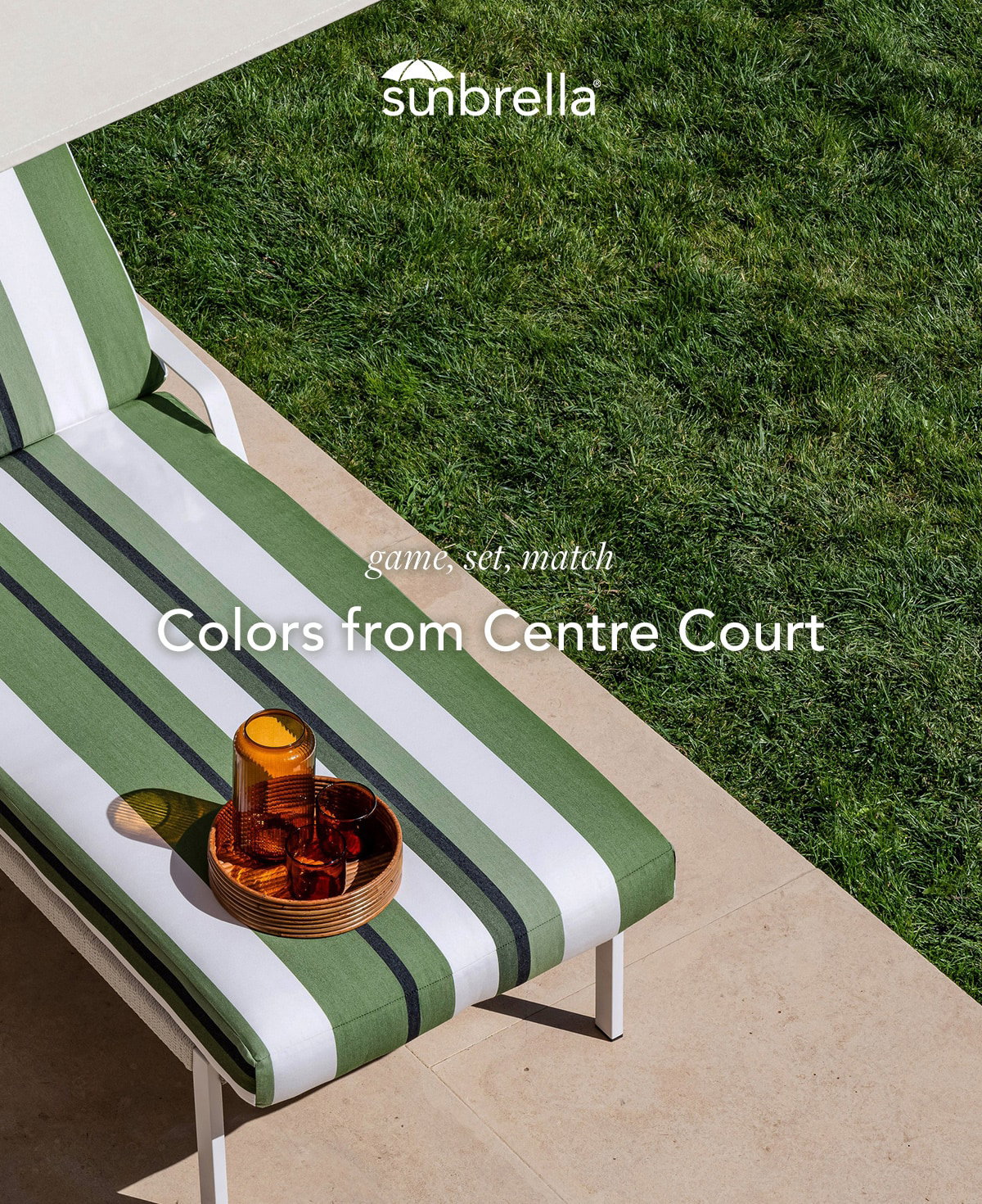 Lounge chair with green and white striped cushion on a patio beside a lush grass lawn, styled with amber glassware and tray, with text reading “Game, set, match. Colors from Centre Court.”