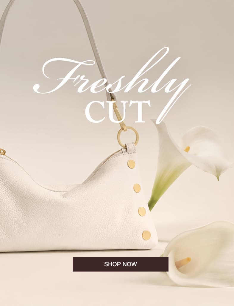 Close-up of the Kyle sml in Calla Lily shoulder bag in Calla Lily White pebbled leather with calla lily flowers and the message "Freshly Cut."