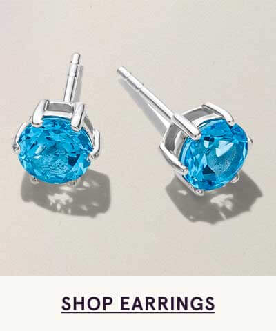 Pair of vibrant, round-cut blue topaz studs set in silver. Click here to shop earrings