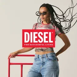 Vrouw met gevlochten haar en zonnebril, gekleed in een grafisch T-shirt en jeans, leunend op een rood metalen frame tegen een effen achtergrond.