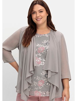 Model in taupefarbenem Chiffonshirt mit Blütendruck und Volants im Vorderteil.