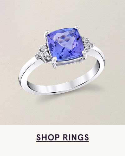 Cushion-cut violet gemstone ring with diamond side accents in white metal. Click here to shop rings