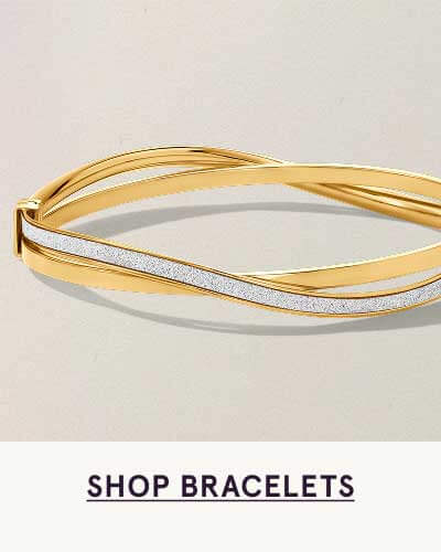 Yellow gold crossover bangle featuring sweeping line of a shiny silver color. Click here to shop bracelets