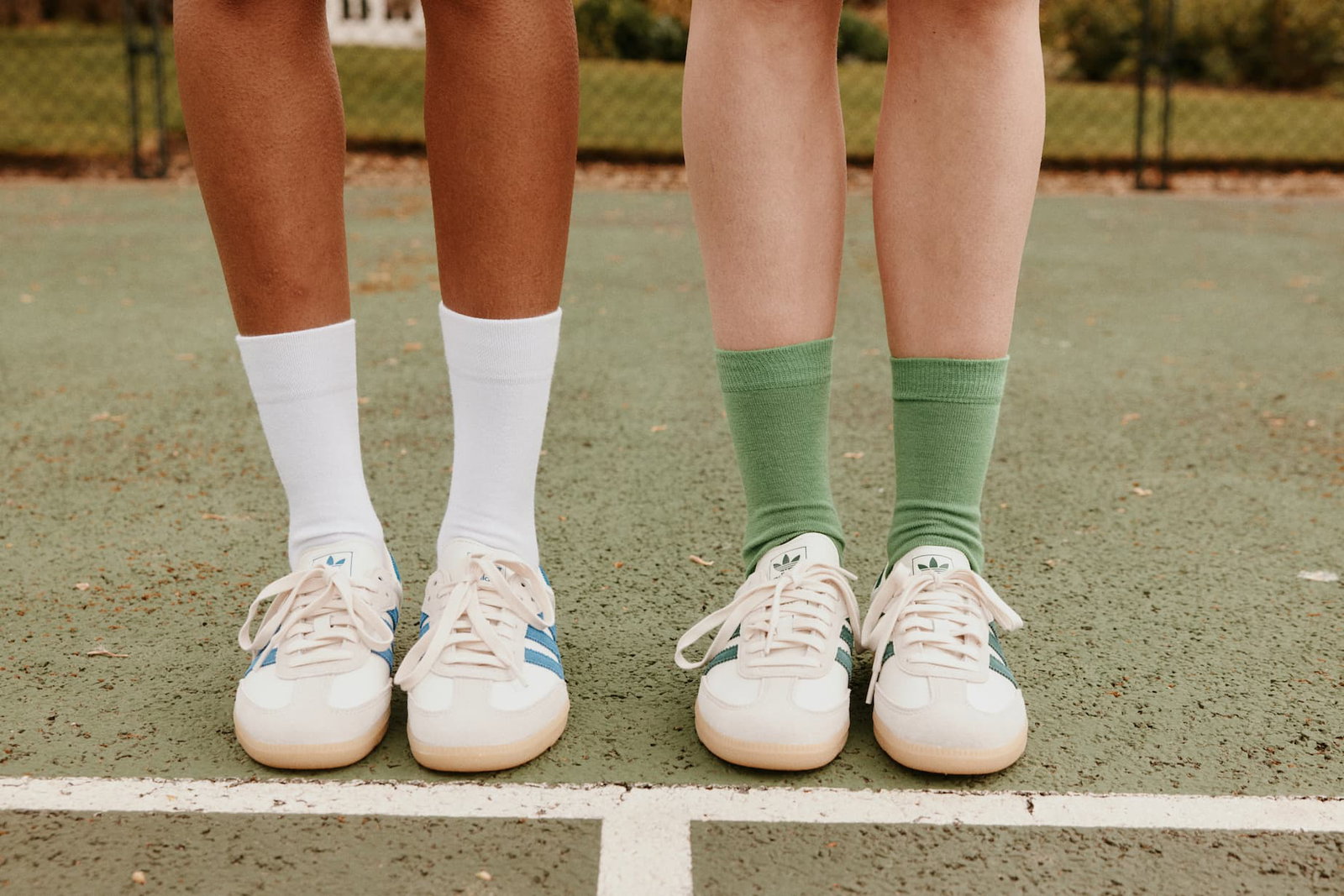 Clean White Bamboo and Grass Green Merino socks worn by models on a tennis court